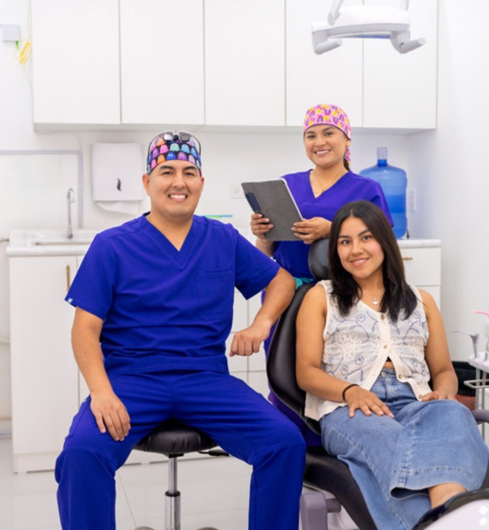 A dentist, a dental nurse and a smiling patient in a dental clinic