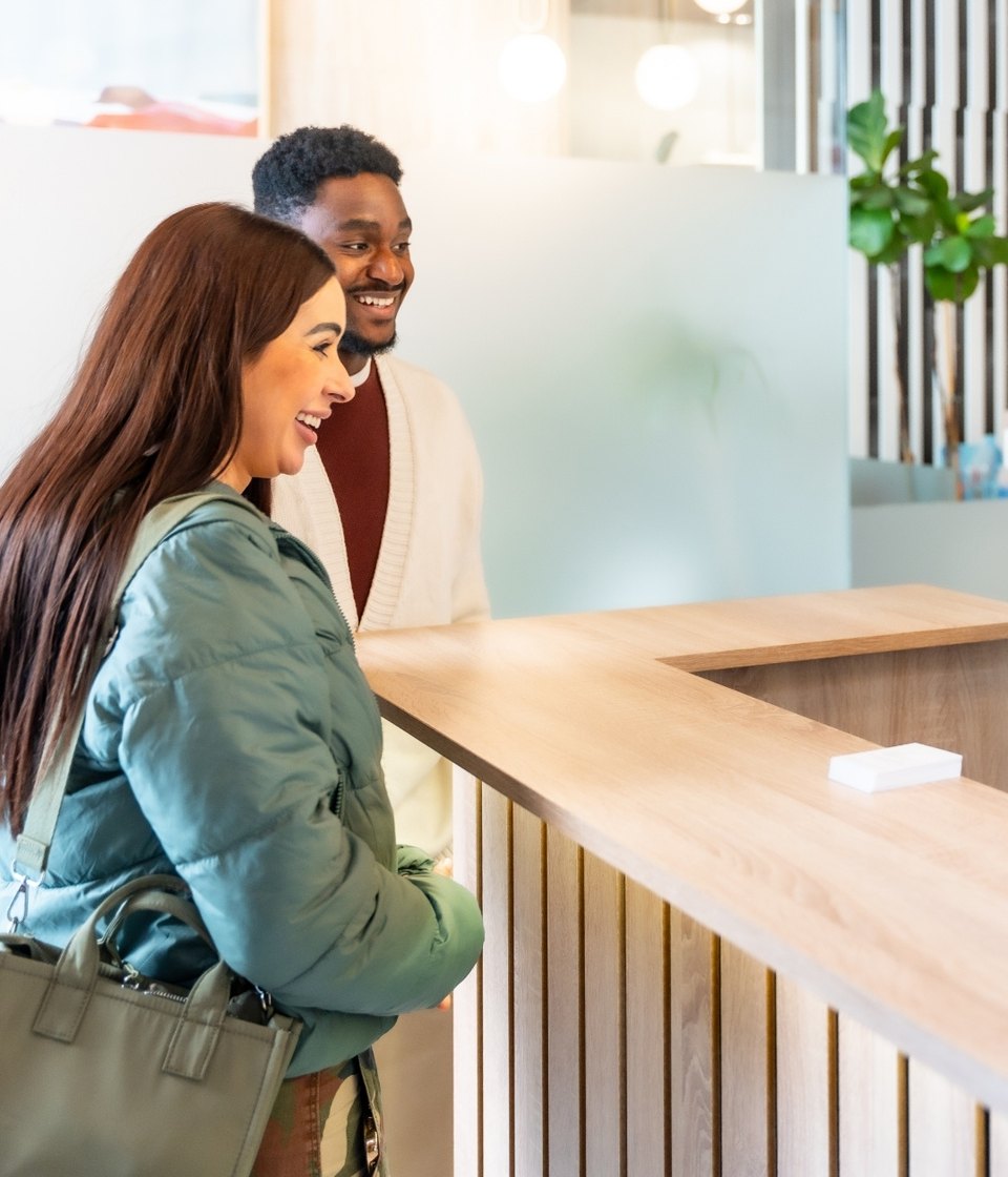 Patients smiling at a dental clinic reception