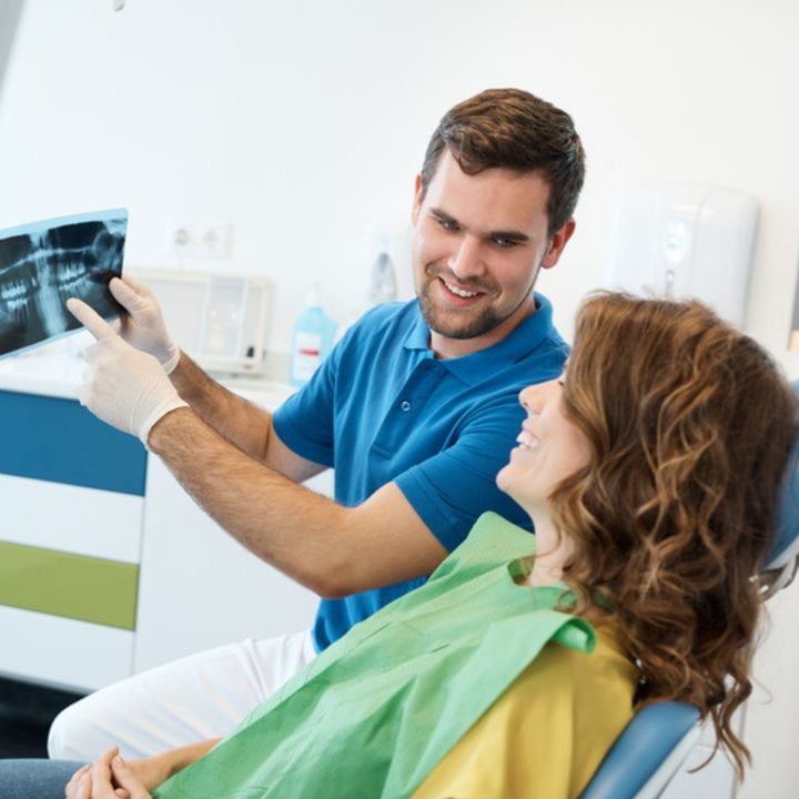 A dentist showing an x-ray to a smiling patient